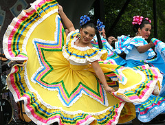 A woman dancing in a colorful dress on Cinco de Mayo.