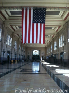 A large flag hanging in a long hall of windows at Kansas City\'s Union Station.