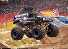 A monster truck with all four tires in the air at Monster Jam at Mid America Center.