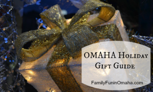 A close up of an outdoor holiday decoration of a gift that reads, \"Omaha Holiday Gift Guide.\"