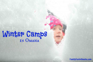 A close up of a child looking into a snow fort with overlay text that reads Winter Camps in Omaha
