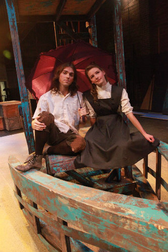 Two stage performers sitting on props at the Peter & The Starcatcher Open at the Rose Theater.