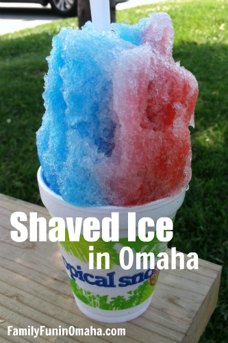 A huge cup of red, white, and blue shaved ice with overlay text that reads Shaved Ice in Omaha