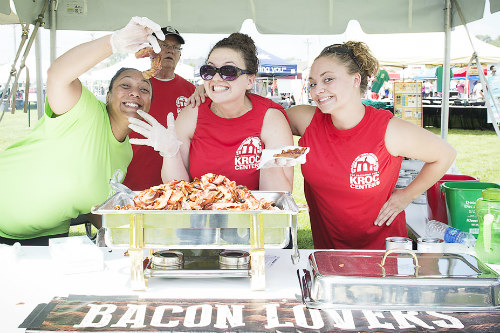 A group of people serving food at BaconFest Omaha.