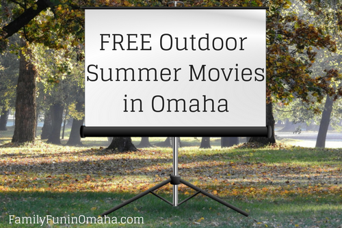 A portable movie screen over a grassy area with trees in the background that reads Free outdoor summer movies in Omaha