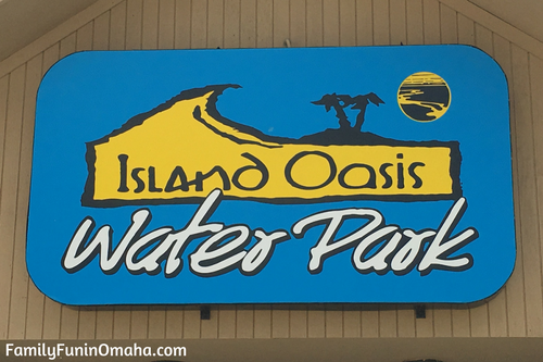 A sign on a building that reads, \"Island Oasis Water Park.\"