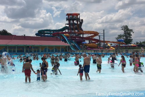 A group of people walking swimming in a wave pool at Oceans of Fun.