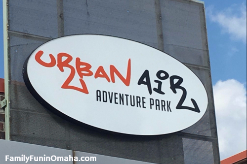 A sign on the side of a building that reads, \"Urban Air Adventure Park.\"