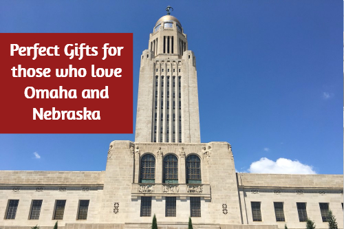 A large tall tower against a blue sky with overlay text that reads, \"Perfect Gifts for those who love Omaha Nebraska.\"