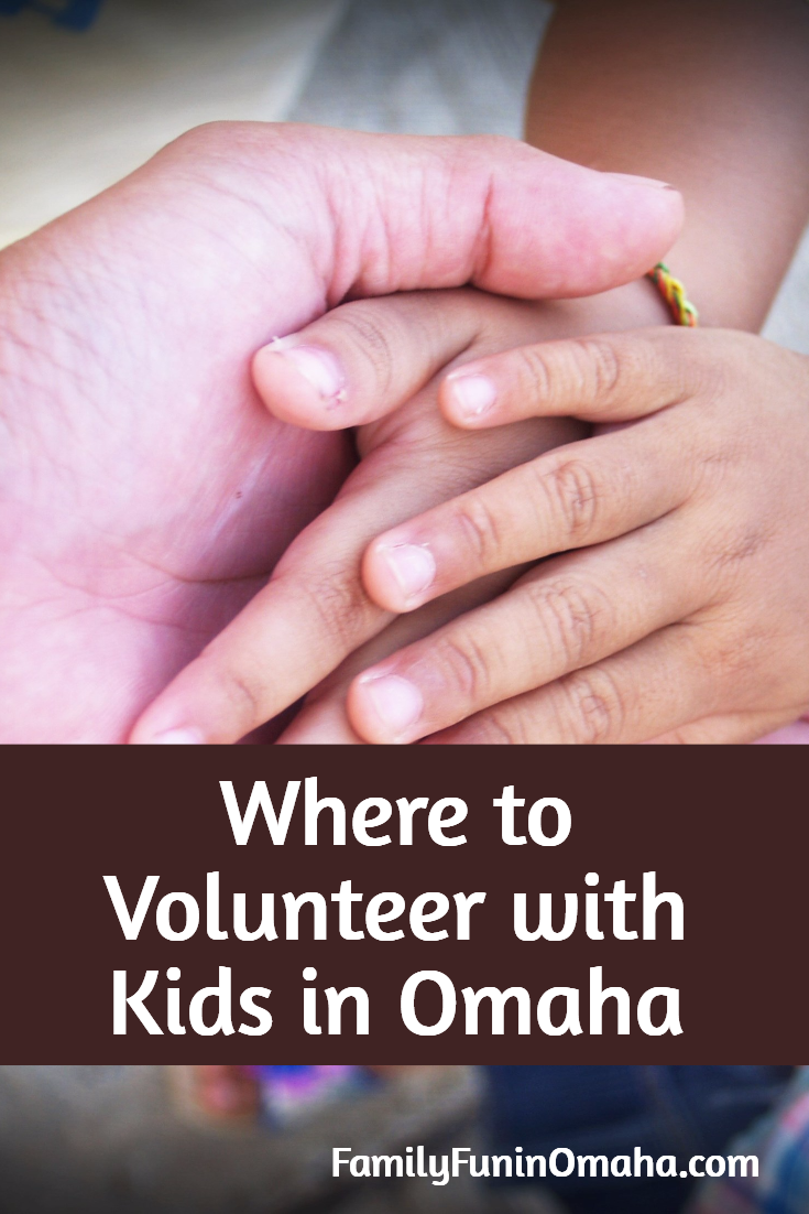 A close up of a group of hands with overlay text that reads, \"Where to Volunteer with Kids in Omaha.\"