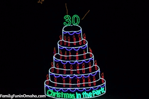A close up of a lighted Christmas Display shaped like a cake that reads \"30 Christmas in the Park\" in Kansas City.