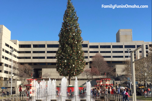 An outdoor tree decorated for Christmas in front of a fountain in Kansas City.