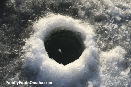 A close up of an ice fishing hole