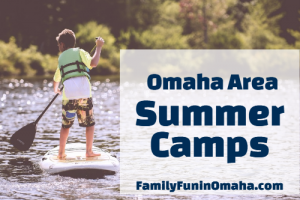 A young boy paddleboarding on a lake with overlay text that reads Omaha Area Summer Camps