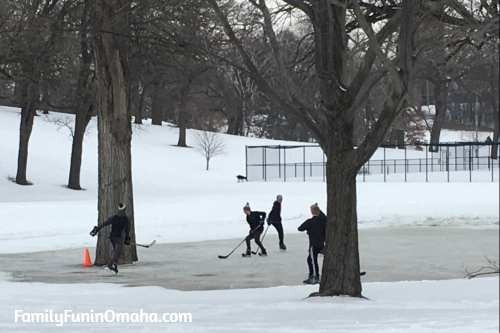 A group of people playing hockey on a  pond in Minnesota.