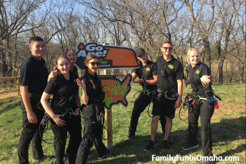 A group of employees with harnesses at Go Ape Treetop Adventure Course at Mahoney State Park. 