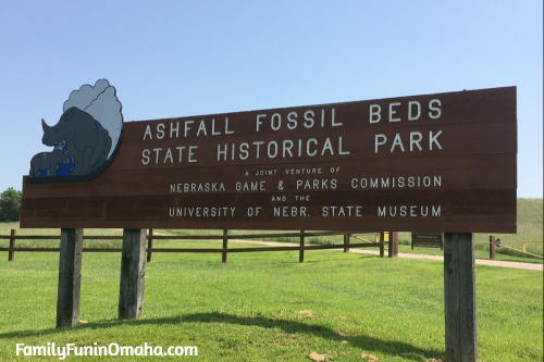 A wooden entrance sign for Ashfall Fossil Beds. 