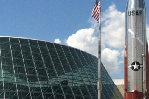 A close up of glass-roofed building and a flag pole