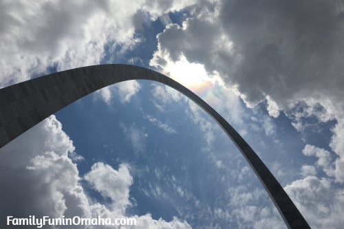 A close up of the St. Louis Arch with clouds in the sky.