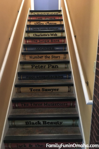 A stairwell faux painted to look like book covers at the St. Louis The Magic House.