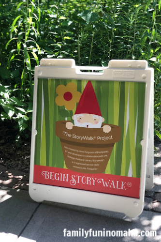 A colorful plastic sign that reads Begin Store Walk at The Great Gnome Escape at Lauritzen Gardens.