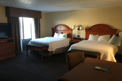 A guest bedroom with two beds and desk at the Hampton Inn in Waterloo.
