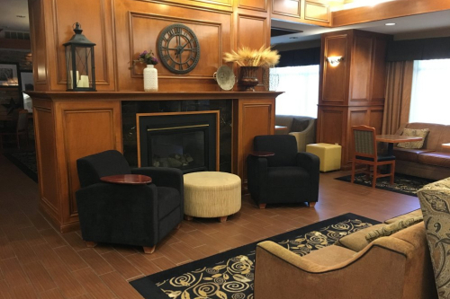 A living area filled with furniture and a fireplace at the Hampton Inn in Waterloo.