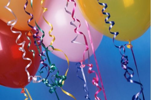 A close up of party balloons on a blue background. 