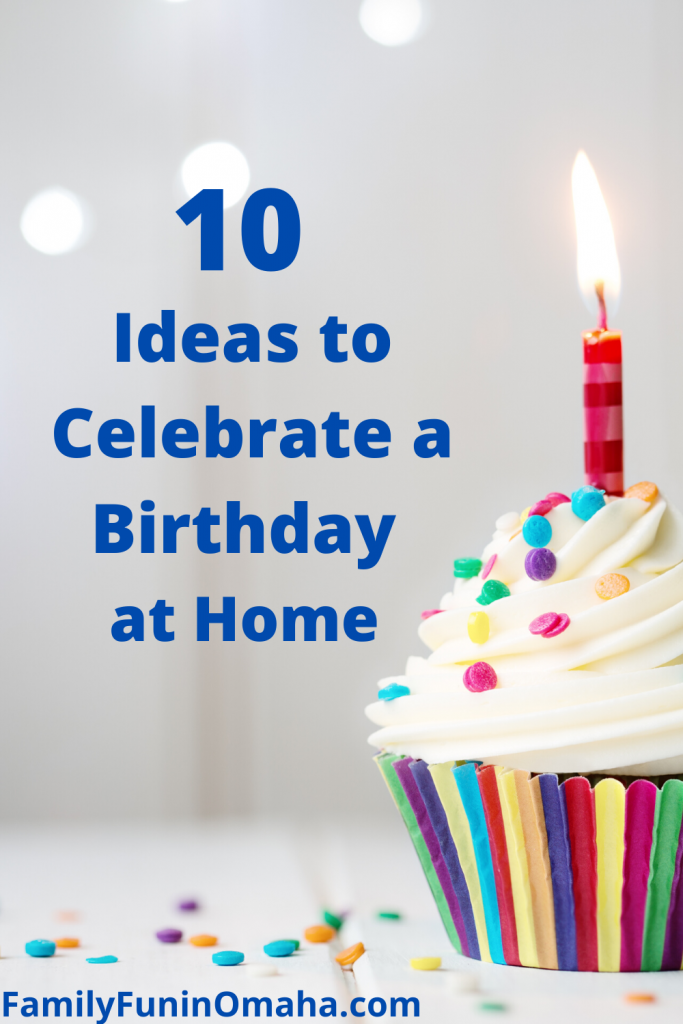 A close up of a colorful cupcake with a lit candle with overlay text that reads, \"10 Ideas to Celebrate a Birthday at Home.\"