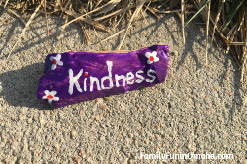 A close up of a painted rock that reads \"kindness.\"