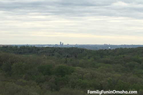 A large green field with a city in the background at Hitchcock Nature Center.